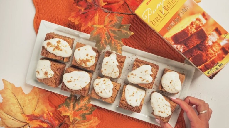 Hand reaches for a plate of Pumpkin Bread & Muffin Mix