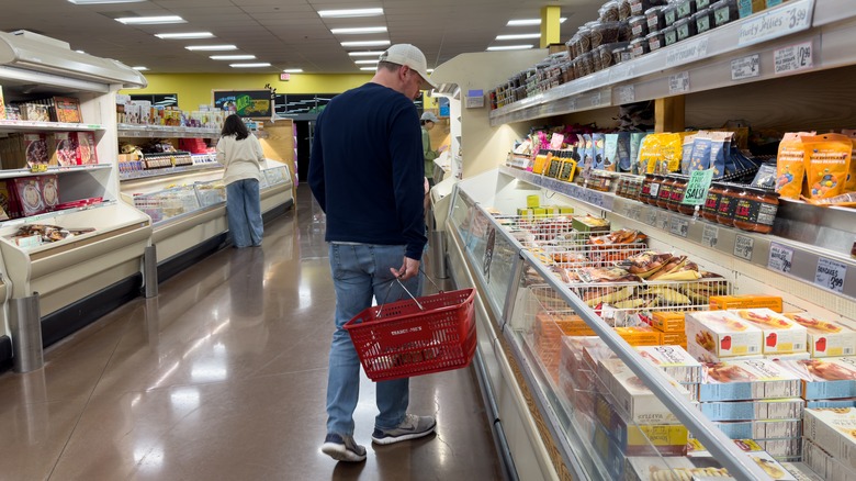 a man in baseball cap shopping the Trader Joe's frozen aisle