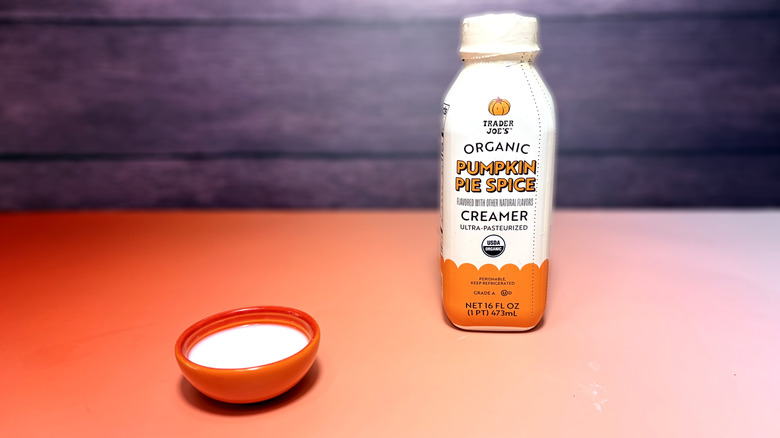 trader joe's pumpkin spice creamer poured into small bowl in front of product container