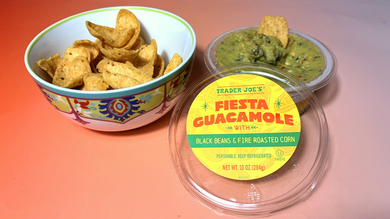package of trader joes fiesta guacamole next to bowl of corn chips