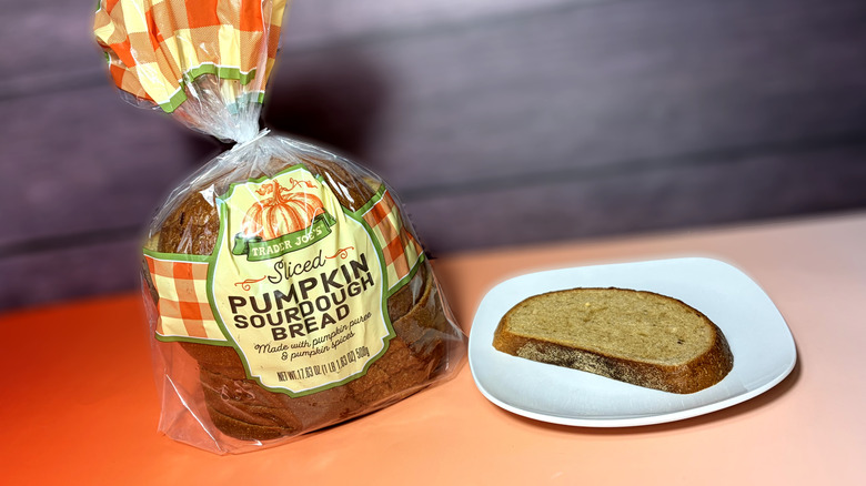 slice of trader joes pumpkin sourdough bread on plate next to packaged loaf