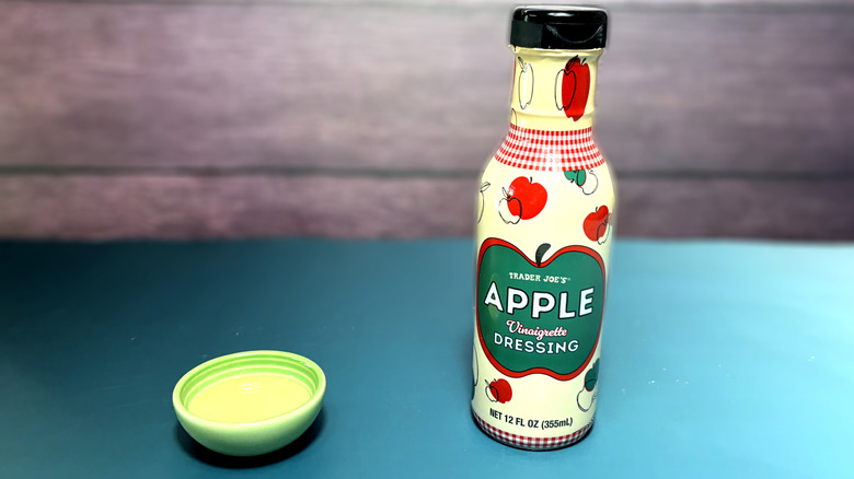 trader joes apple vinaigrette dressing poured in mini bowl next to product bottle