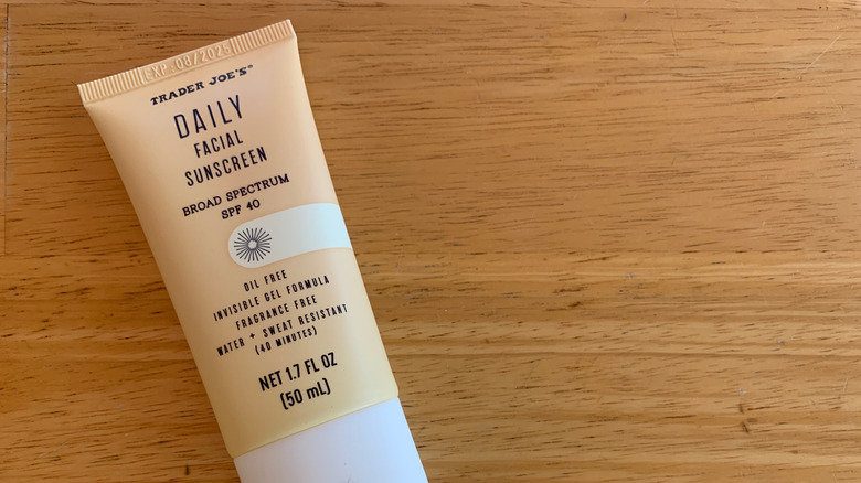 A close-up of Trader Joe's facial sunscreen on a wooden table