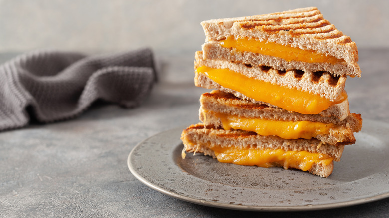 stacked grilled cheese halves on gray plate