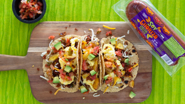 a package of Trader Joe's Soy Chorizo next to a cutting board with tacos and salsa
