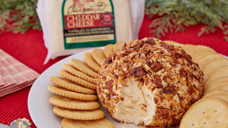 A package of Trader Joe's Unexpected Cheddar Cheese next to a cheese dish and chips