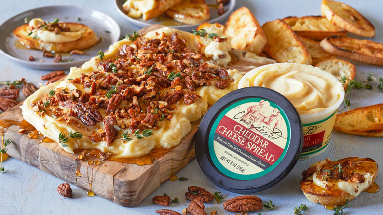 Unexpected cheddar spread tub with spread on wood board
