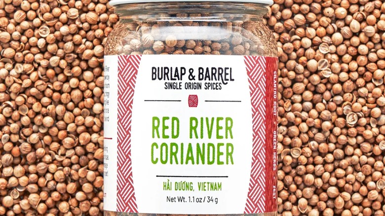 Jar of coriander seeds on top of coriander seeds