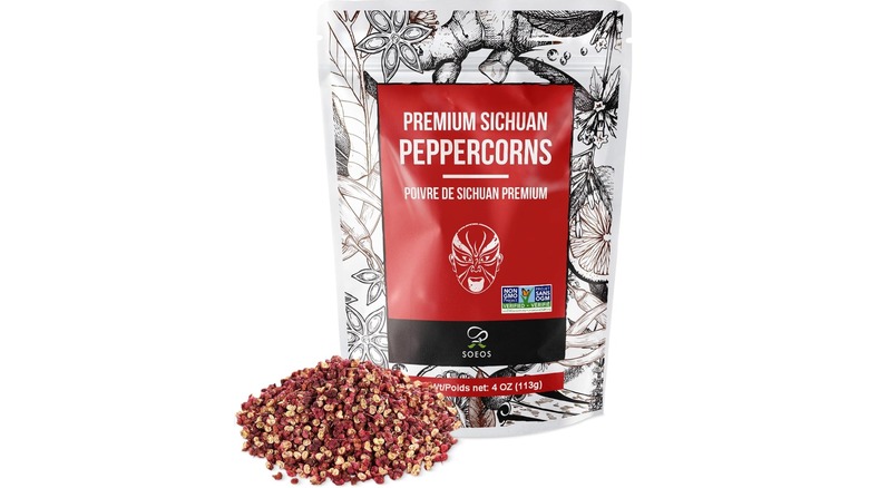 Bag of sichuan peppercorns next to a pile of sichuan peppercorns