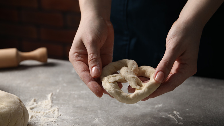 a person holding pretzel dough