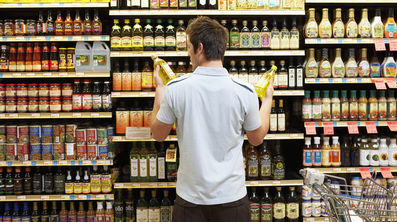 Man comparing products at grocery store