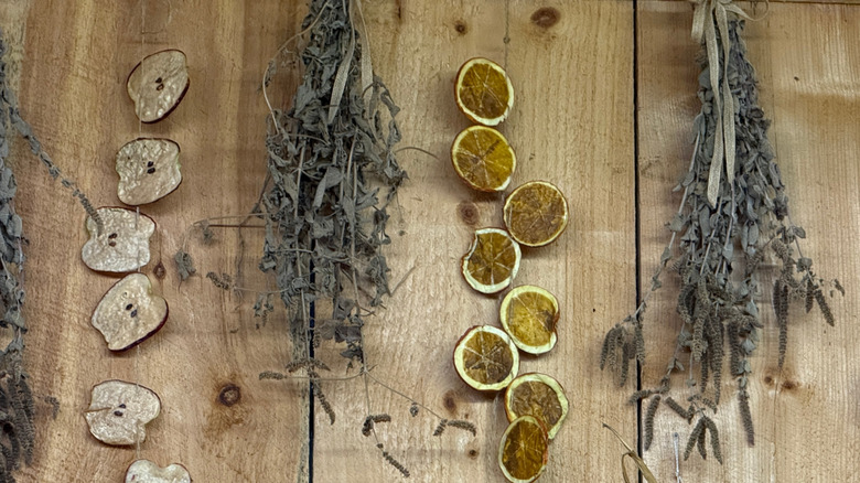 Fruit garlands and dried herbs against a wooden wall or table