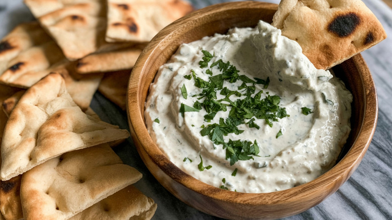 whipped feta dip in a wooden bowl with pita bread