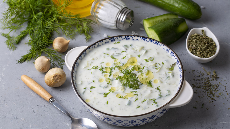 Bowl of tzatzki with cucumber, spices,and garlic in the background