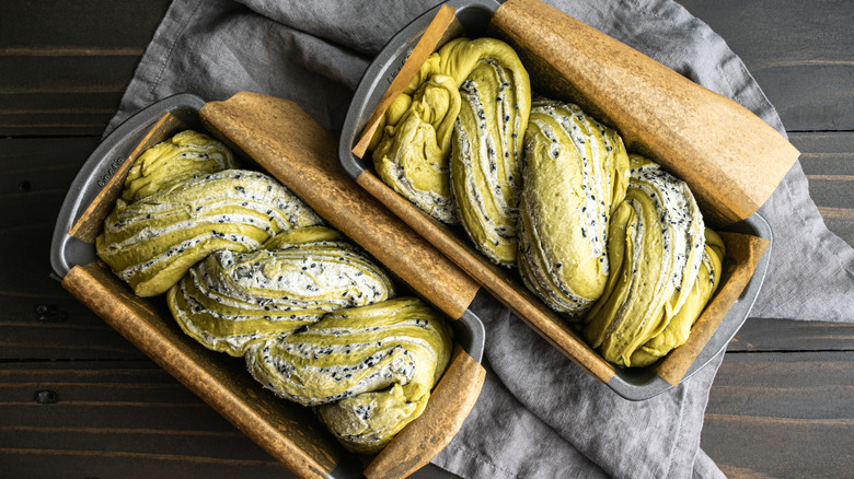 Two loaf pans filled with dough