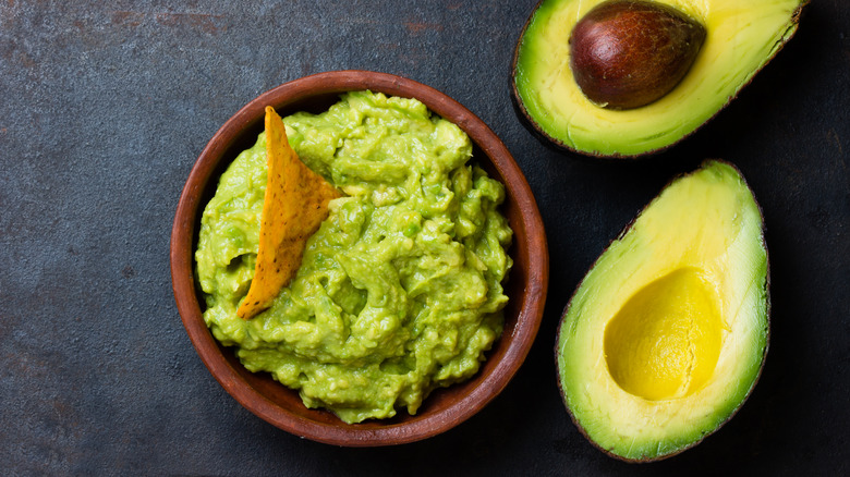 Halved avocado in woman's hands