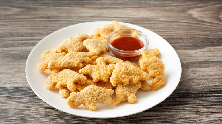A plate of dino nuggets with ketchup