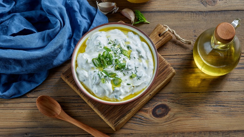 overhead of tzatziki in bowl on wood board