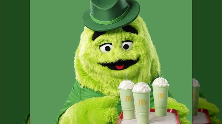 Uncle O'Grimacey holding a tray of three Shamrock Shakes