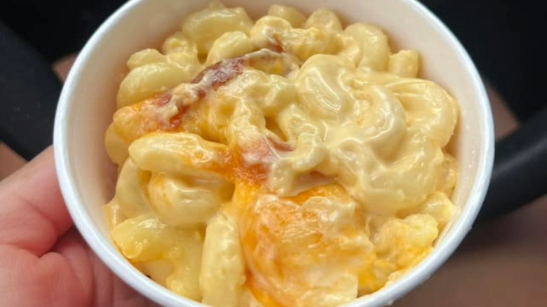 A person holding a bowl full of Mac & Cheese from Chick-fil-A