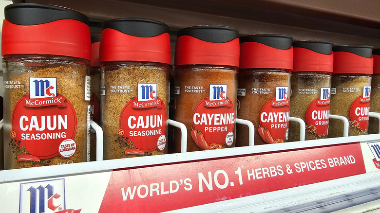 Several McCormick spices lined up together on a store shelf, including Cajun Seasoning