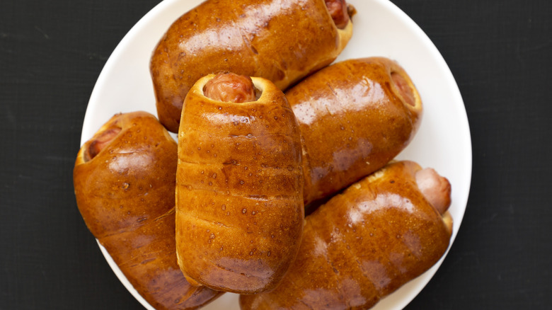 A plate of sausage kolaches with golden brown pastry