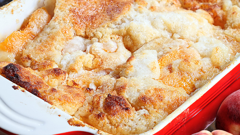 A sonker in a casserole dish, with uneven crumbly looking topping, baked till golden brown