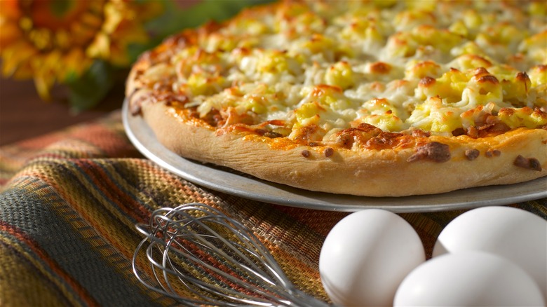 Whole eggs next to breakfast pizza
