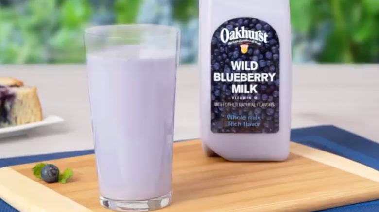 oakhurst dairy blueberry milk in glass on cutting board