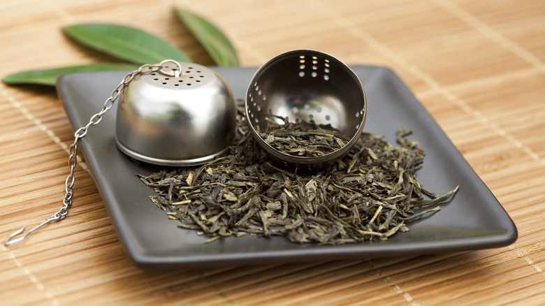 open tea ball with dried herbs on plate