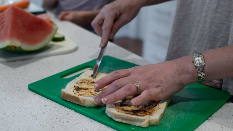 home chef making Vegemite sandwich