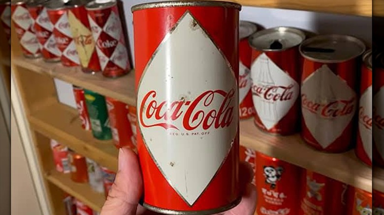 Hand holding a diamond Coca-Cola can from a collection