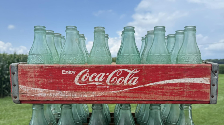 A collection of vintage Coke bottles in a crate