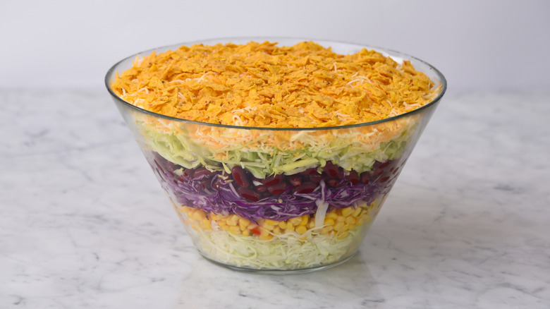 Seven-layer salad in a glass bowl, showing its layers
