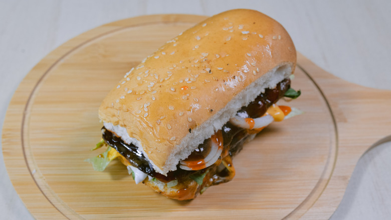 A burger dog placed on a wooden board on a table