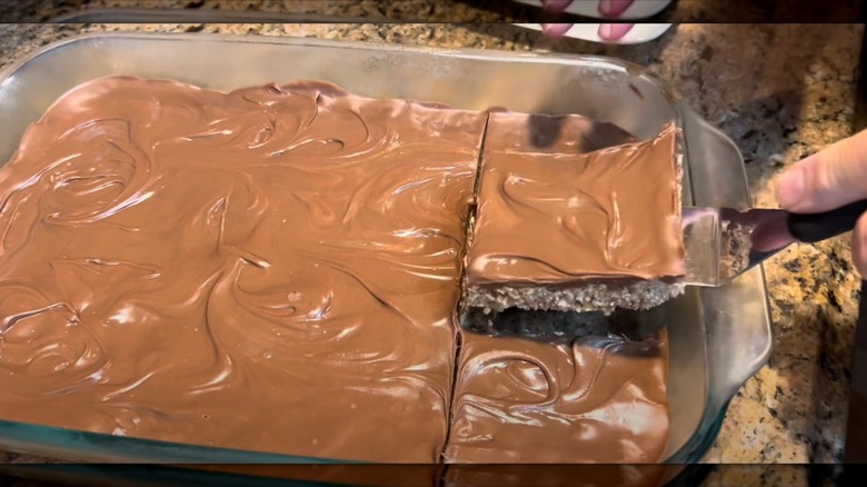 A hand lifts an Oh Henry bar out of a just-prepared batch