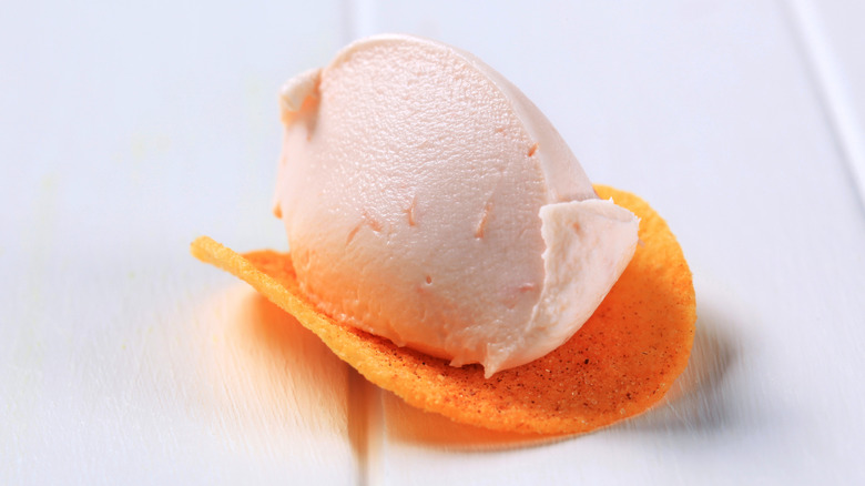 A scoop of salmon mousse sits on a potato chip