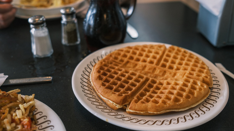 Waffle on plate next to breakfast food