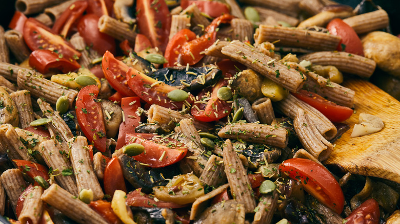 Pasta salad with a wooden spoon close up