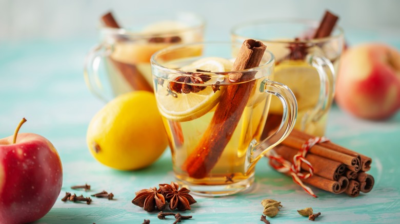 Three glass mugs of wassail with lemon and spices