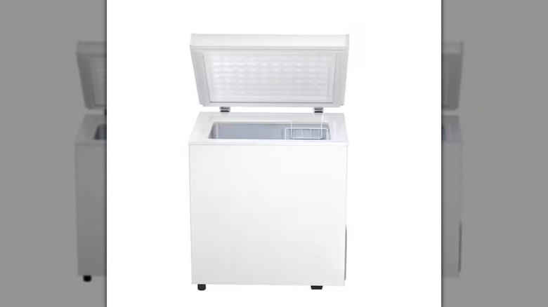 A rectangular white chest freezer, open to show sorting basket inside