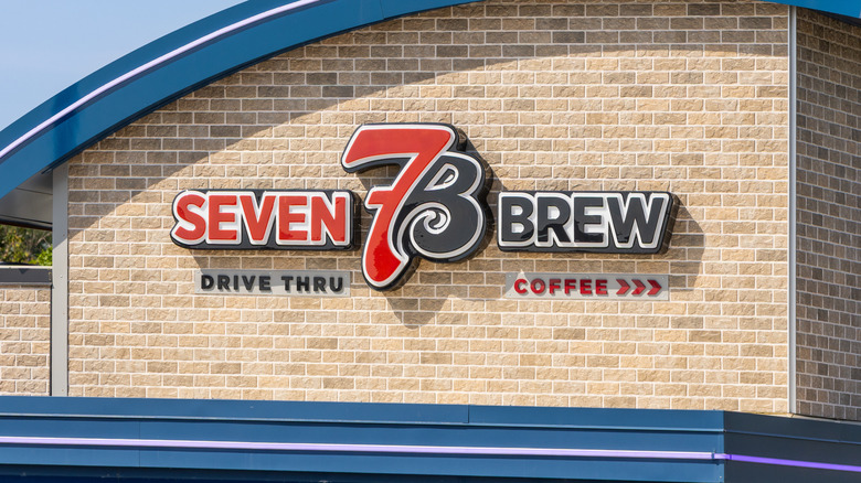 The black, red, and white Seven Brew Drive Thru sign on the side of a Seven Brew location