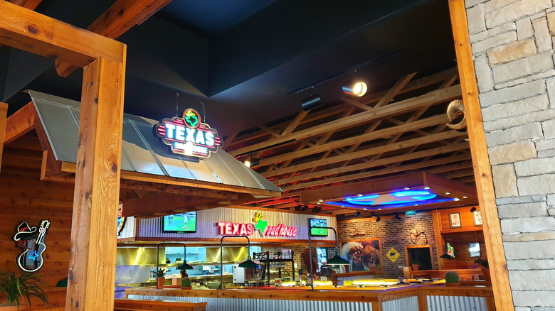The interior of a Texas Roadhouse location with signs and assorted decor.
