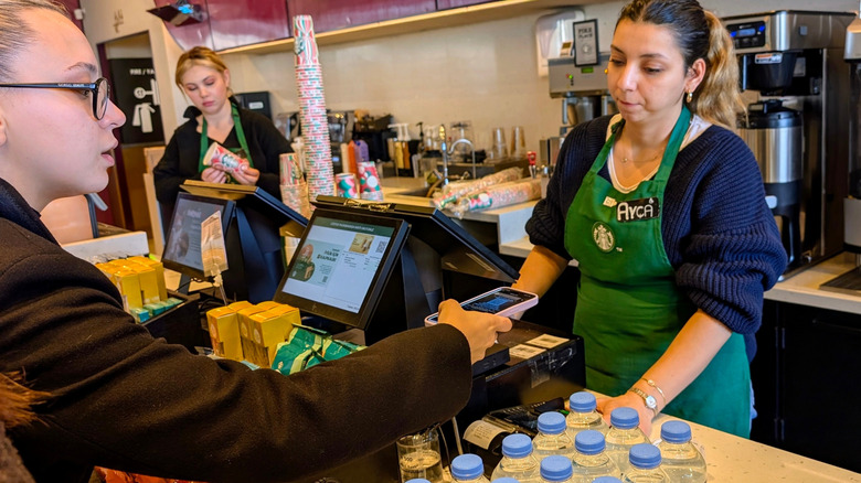 A customer pays using their phone at a Starbucks coffee shop