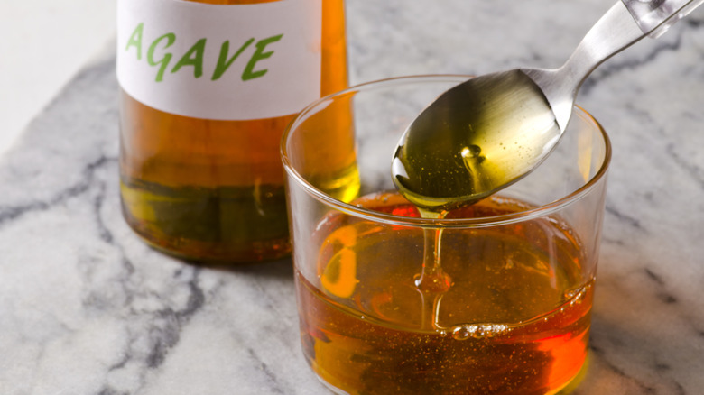 agave syrup in tumbler with spoon marble table