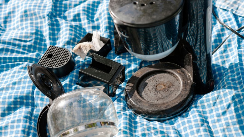 disassembled automatic coffee maker on blue cloth