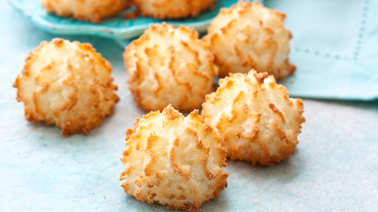 Five coconut macaroons, with well-toasted peaks of whipped egg whites, on a blue table