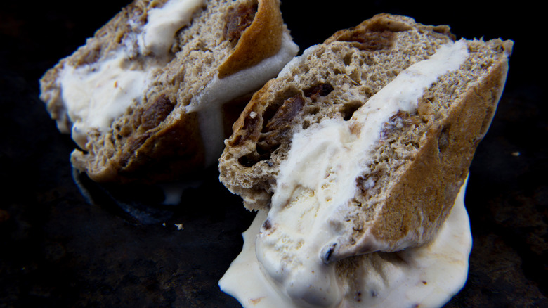 Two ice cream sandwiches made with cakey cookies on a dark background