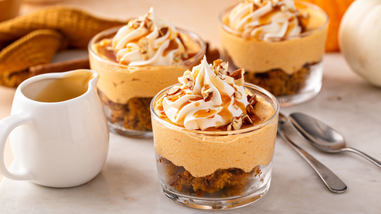 Three no-bake pumpkin bread cheesecakes in glasses on a table