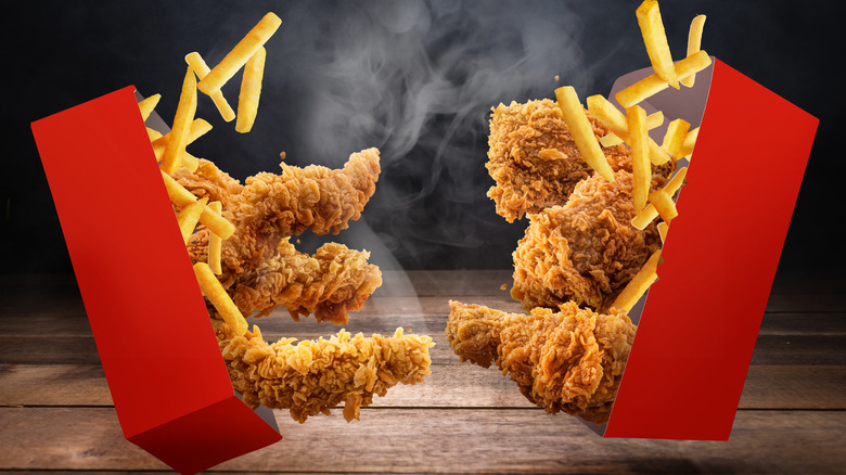 chicken tenders and fries spilling out of red containers